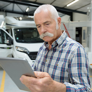 Mechanic looking up old RV owner's manual on tablet