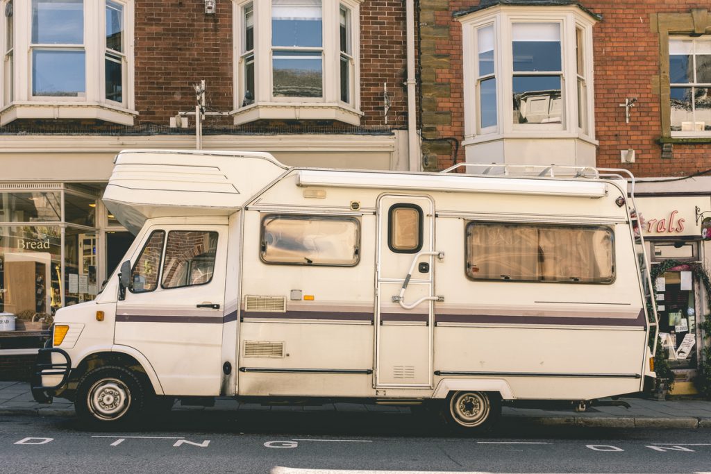 A used class A sits on a city street. Inspecting an RV like this is important to know about buying a used RV