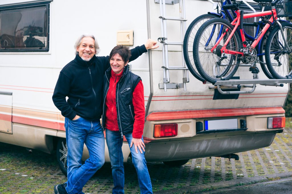 A couple stands outside after buying a used RV