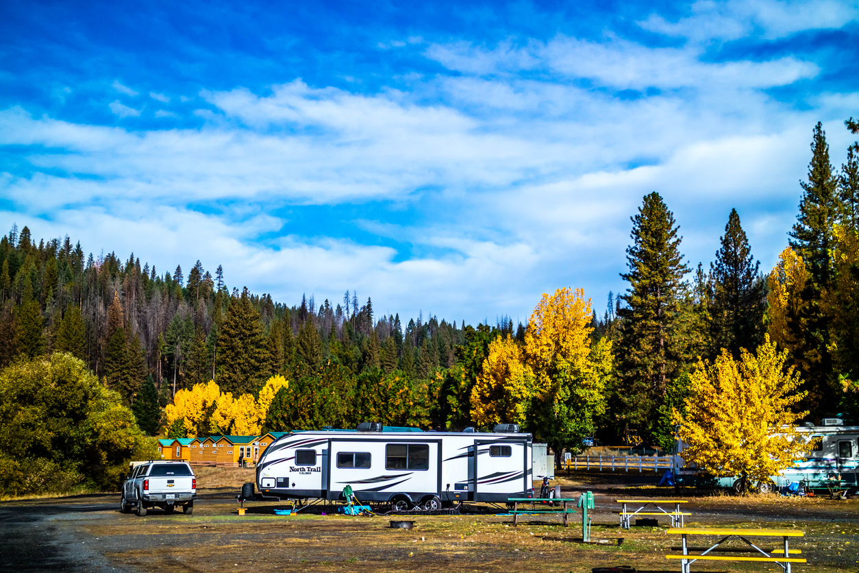 A travel trailer parked in front of a fall scene in the mountains before it sells. Preparing your RV for sale is an important step.