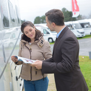 A salesperson helps a customer save money on a new RV