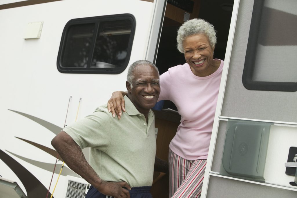 Sell my RV myself: A husband and wife stand in the doorway of their RV.
