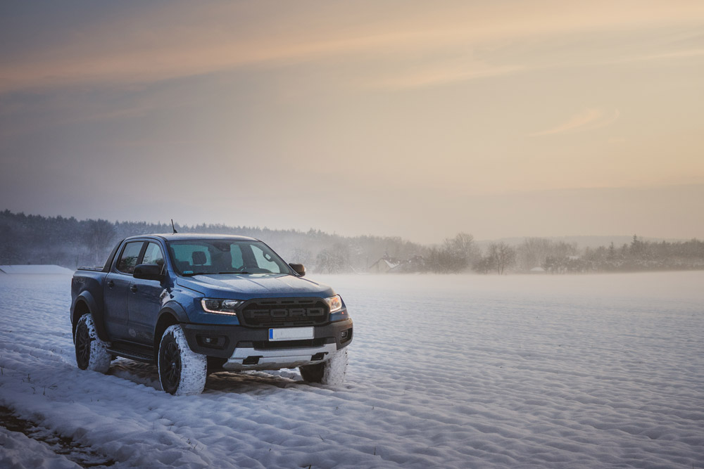 A Ford Ranger drives through the snow at sunset. This is one of the best trucks for towing a 7000 lb. travel trailer