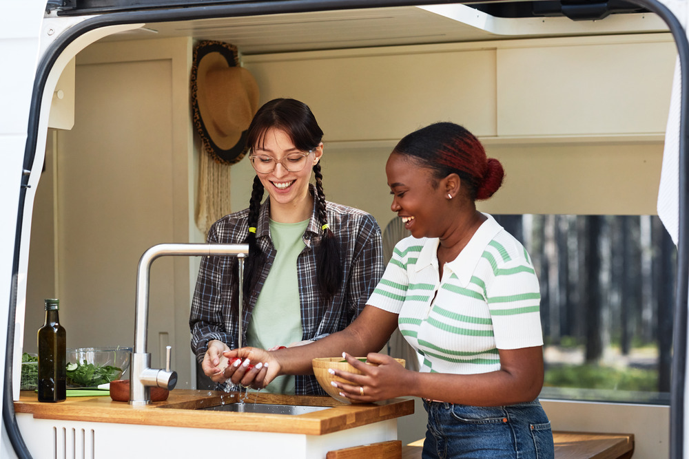 two women cooking food in RV camper