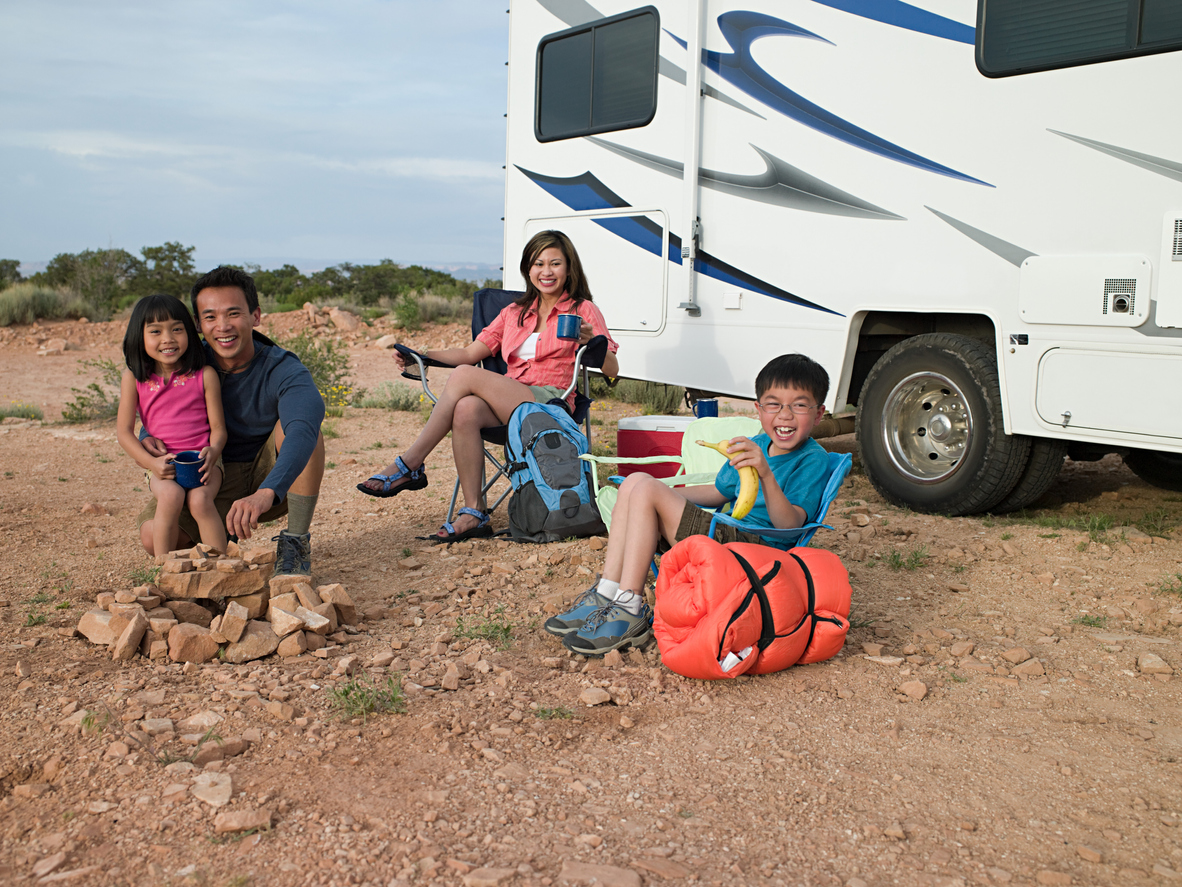 Kids sit outside RV with parents
