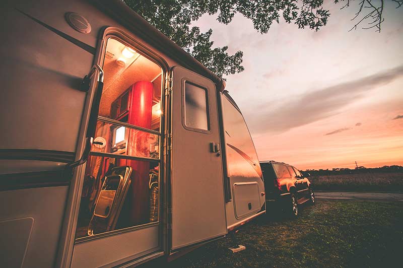 An RVUSA travel trailer at sunset
