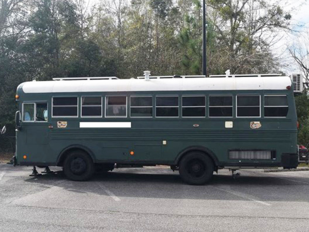 The exterior of a green skoolie for sale