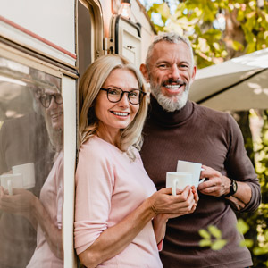 A couple hangs outside their RV with coffee