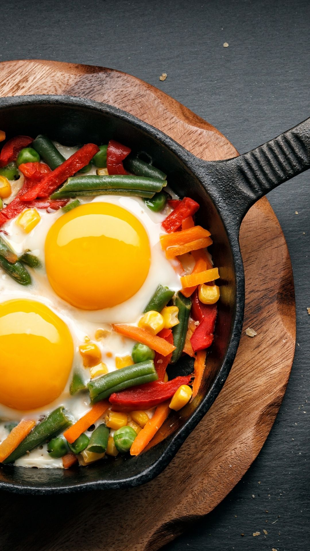 A cast iron pan with eggs and vegetables is a great way to cook breakfast over a campfire