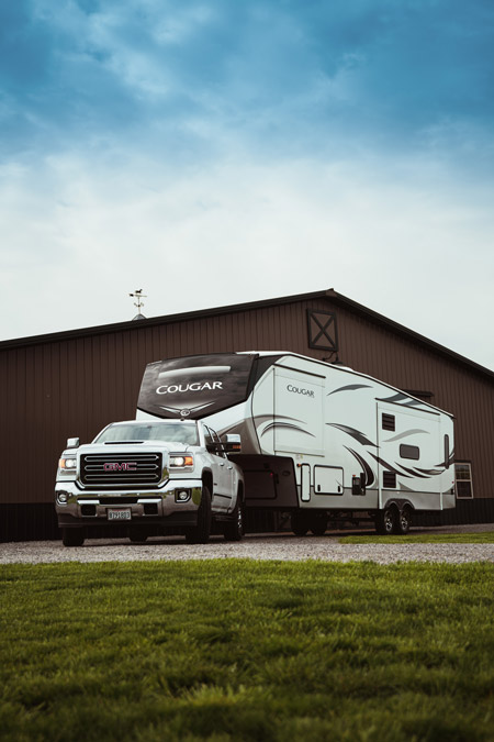 A Keystone Cougar, one of the top 10 most viewed RVs on RVUSA sits parked in front of a horse barn.