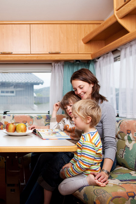 A mom reads with her two kids as part of a roadschooling lesson