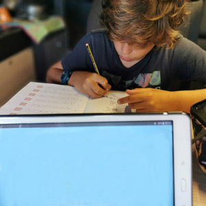 A young boy does his roadschooling homework in the RV