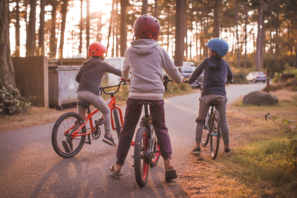 A group of kids ride bikes around a campground