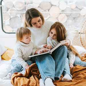 A mom reads a book to kids in an RV