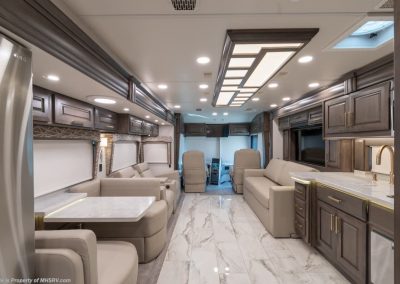 Living area, partial kitchen and captain's chairs in an Entegra Coach Cornerstone.